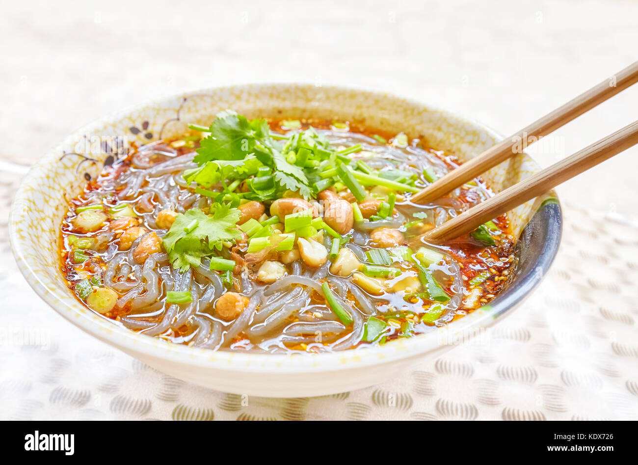 Würzige Nudelsuppe mit Gemüse, Kräutern, Erdnüssen und Koriander, beliebt in der Provinz Yunnan, geringe Tiefenschärfe, China. Stockfoto