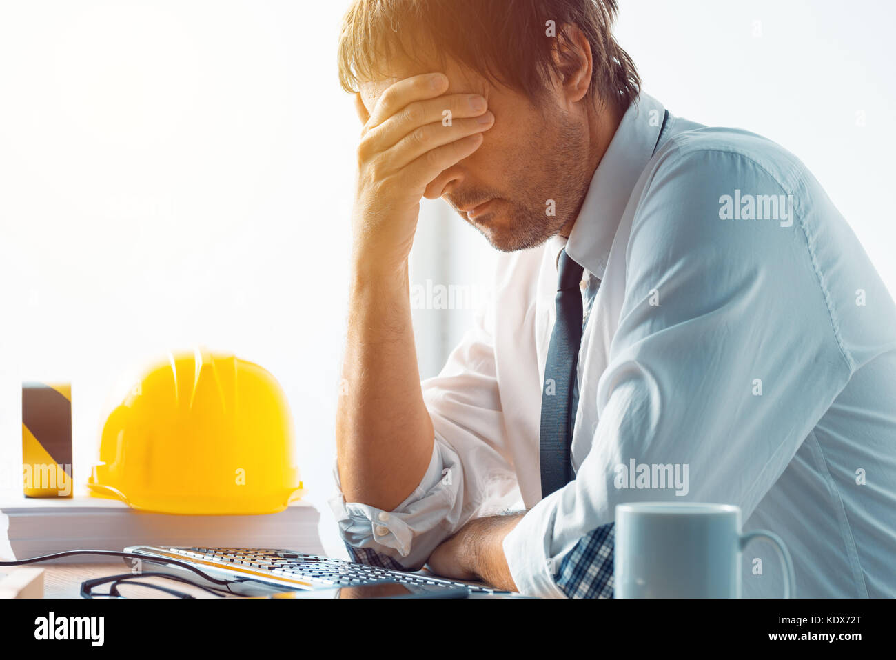 Architekt und Bauingenieur Probleme bei der Arbeit im Büro, Bauingenieur arbeiten mit Computer und Skizzen auf einer Baustelle proj Stockfoto