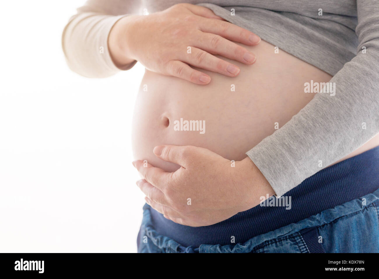 Schwangere Frau berühren und reiben ihren Bauch, Mutter streichelte und anregende Bauch, nach kaukasischen Frauen im fünften Monat oder 20 erste Woche von Stockfoto