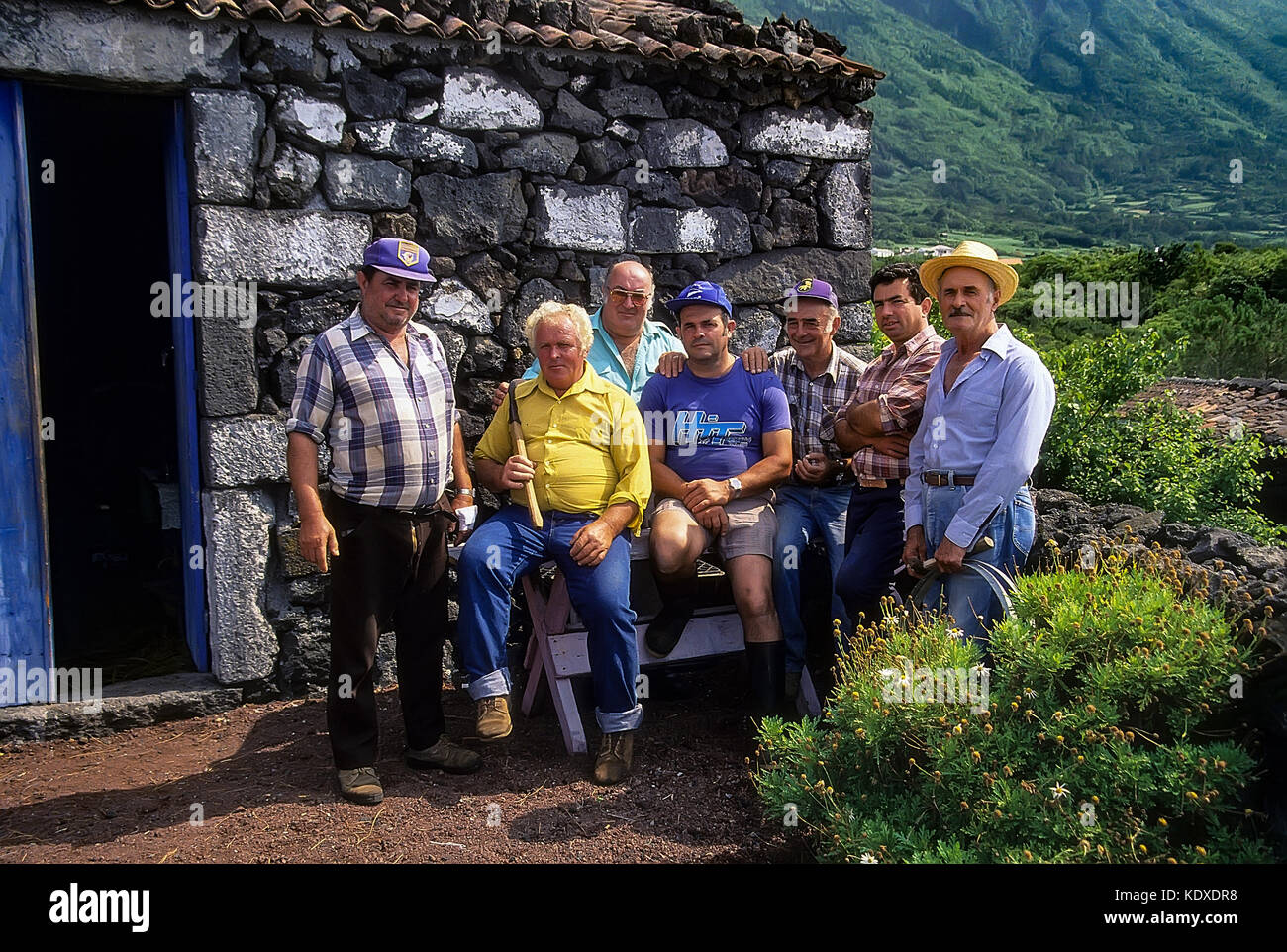 Portrait von sieben verwitterten, Azorian Bauern auf der Insel Pico mit ihrem Lavastein adega, Weinkeller, in San Mateus Dorf, Azoren. Stockfoto