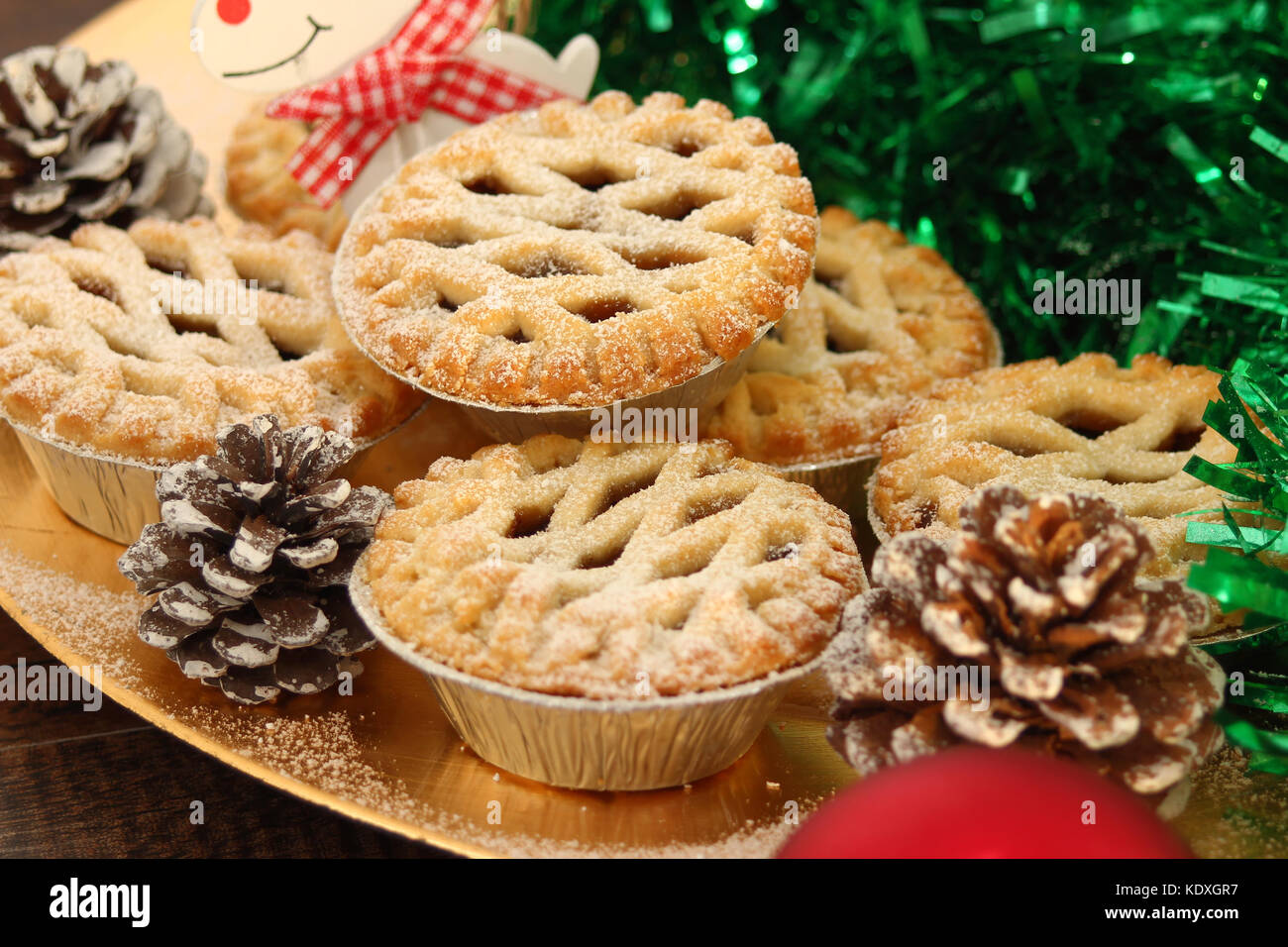 Weihnachten Mince Pies auf einen goldenen Schild mit weißem Rentier auf ein Holz Hintergrund Stockfoto