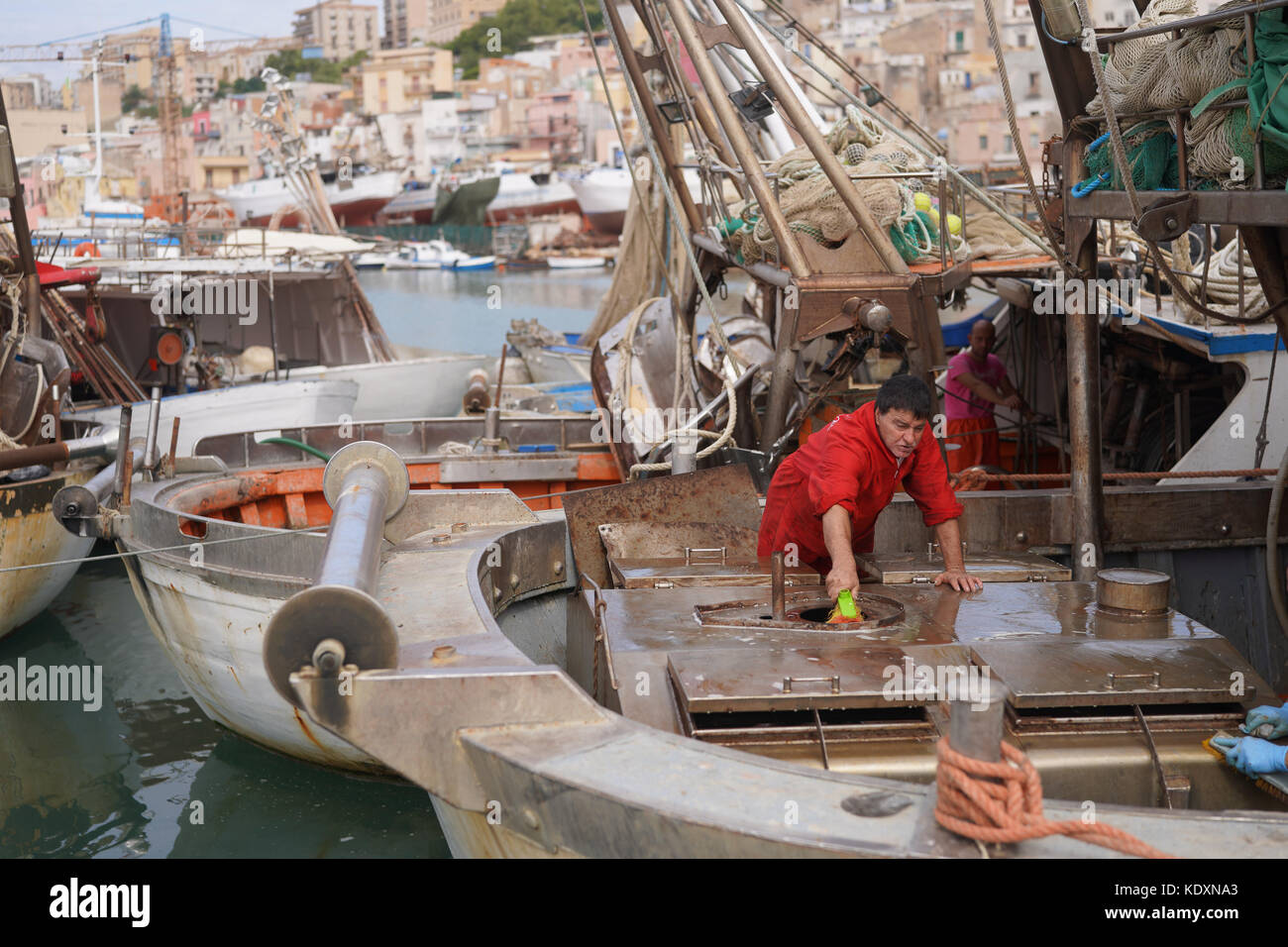 Ein Fischer sein Boot Reinigung während der Fischerei ist ein Monat Embargo im Hafen von Sciacca. Aus einer Serie von Fotos in Sizilien, Italien. foto Datum: Tu Stockfoto
