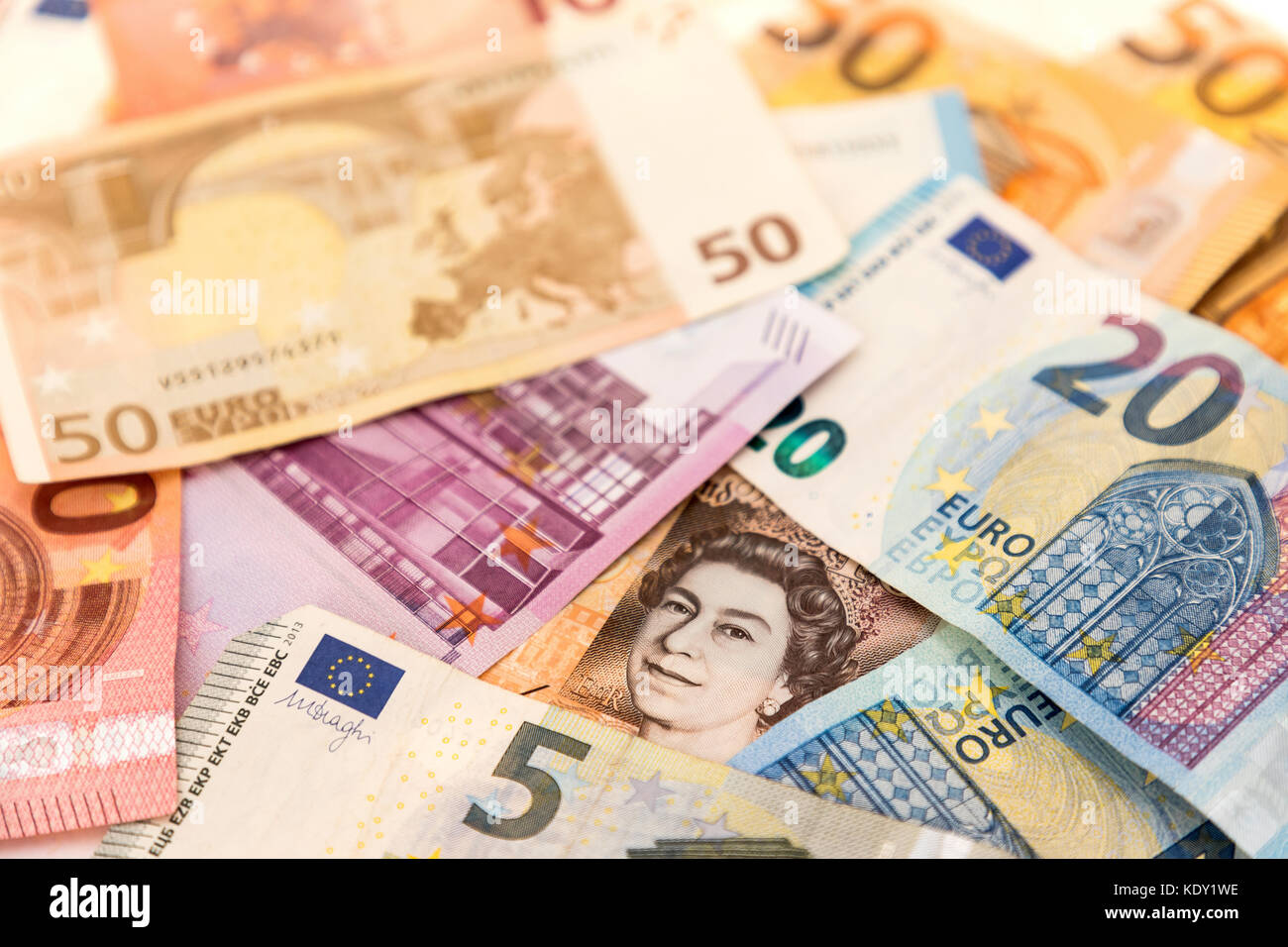 Eine britische Banknote mit einem Bild der Königin, das mit Euro-Banknoten bedeckt ist Stockfoto