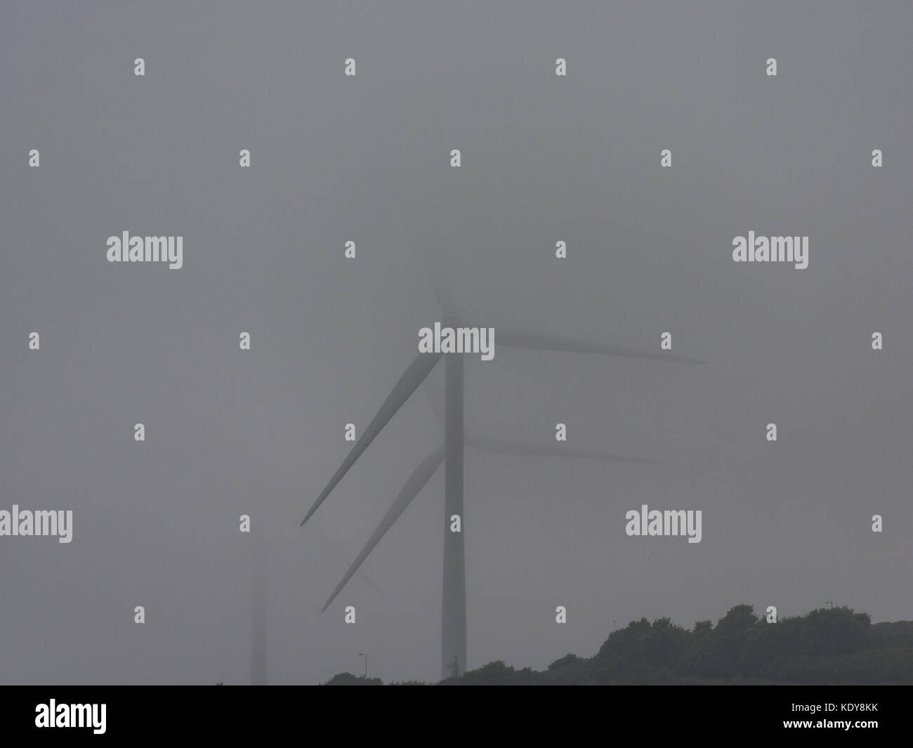 Windkraftanlagen teilweise durch Nebel verborgen Stockfoto