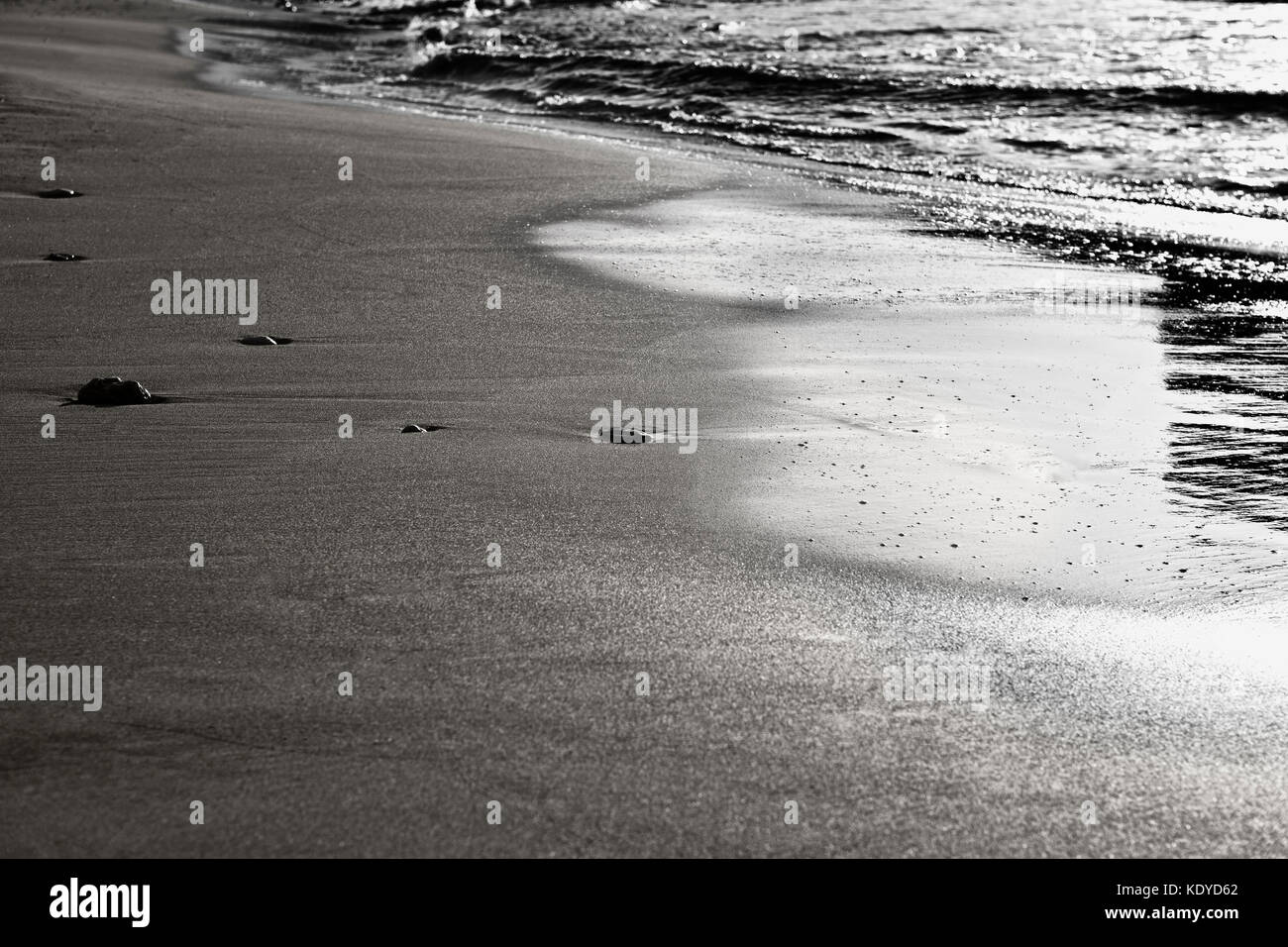 Abstraktes Bild, die sechs Kieselsteinen an einem Sandstrand, scheinbar genießen Sie das sanfte Auf und Ab der Wellen Stockfoto