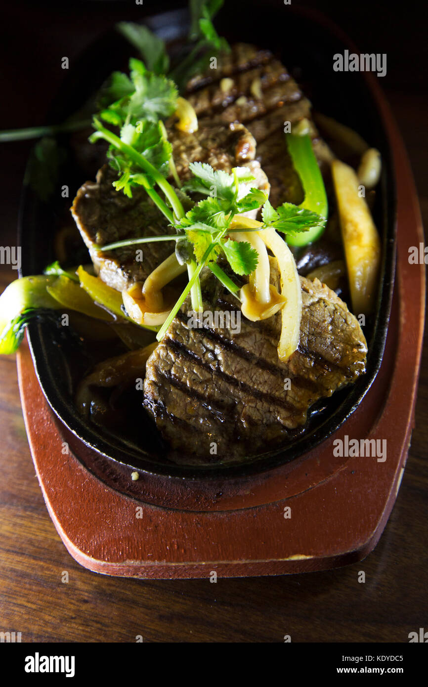 Gegrilltes Rindfleisch Steak serviert mit gebratenen Gemüse und gekrönt mit Koriander. Das Gericht ist ein Beispiel der Fusion-küche. Stockfoto