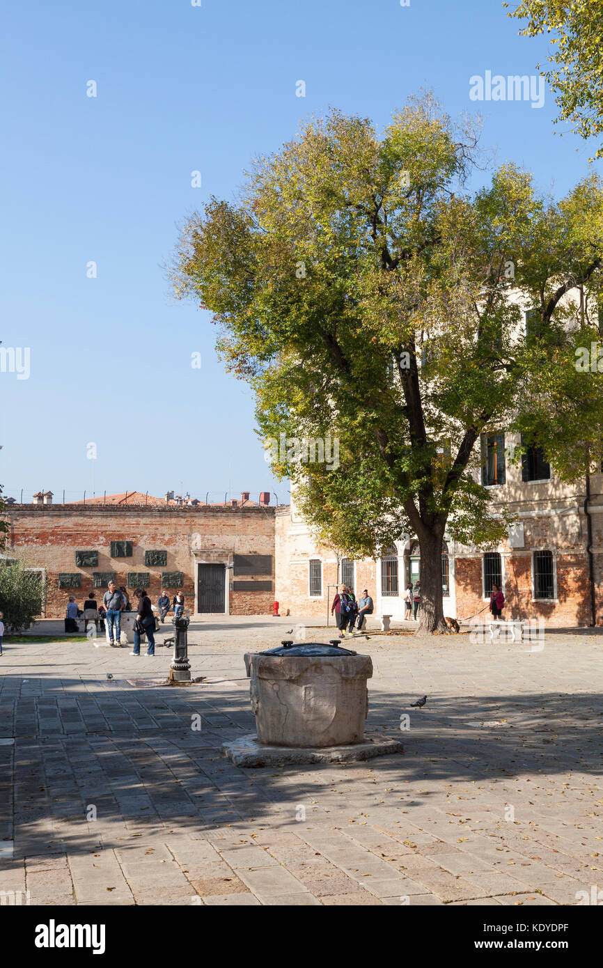 Campo De Gheto Novo, Cannaregio, Venice, Italien im Jüdischen Ghetto mit Blick über den alten Brunnen an der Wand der Erinnerung an den Holocaust vict Stockfoto