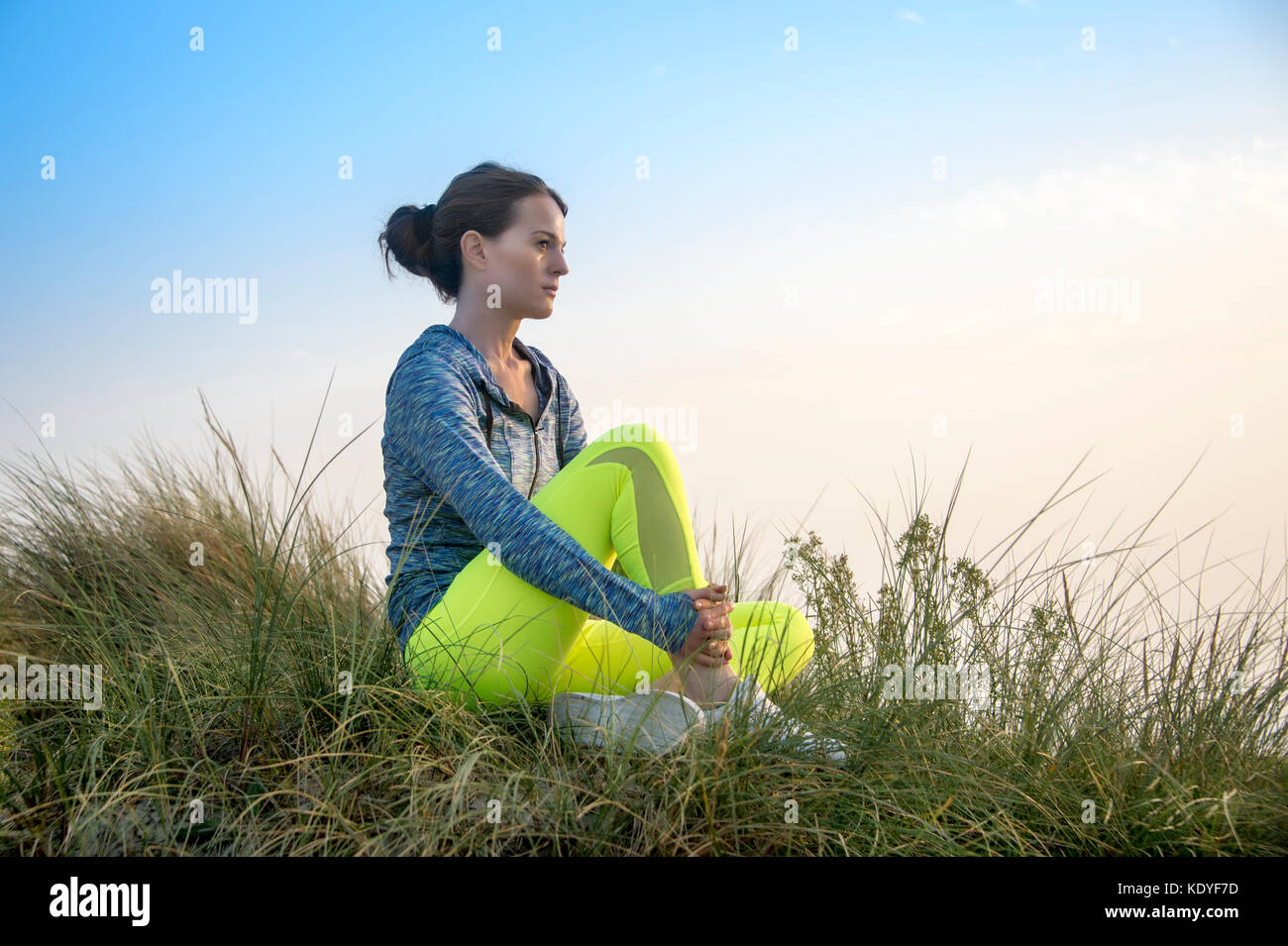 Frau sitzen Ausruhen nach dem Trainieren, bei Sonnenaufgang/Sonnenuntergang laufen Stockfoto