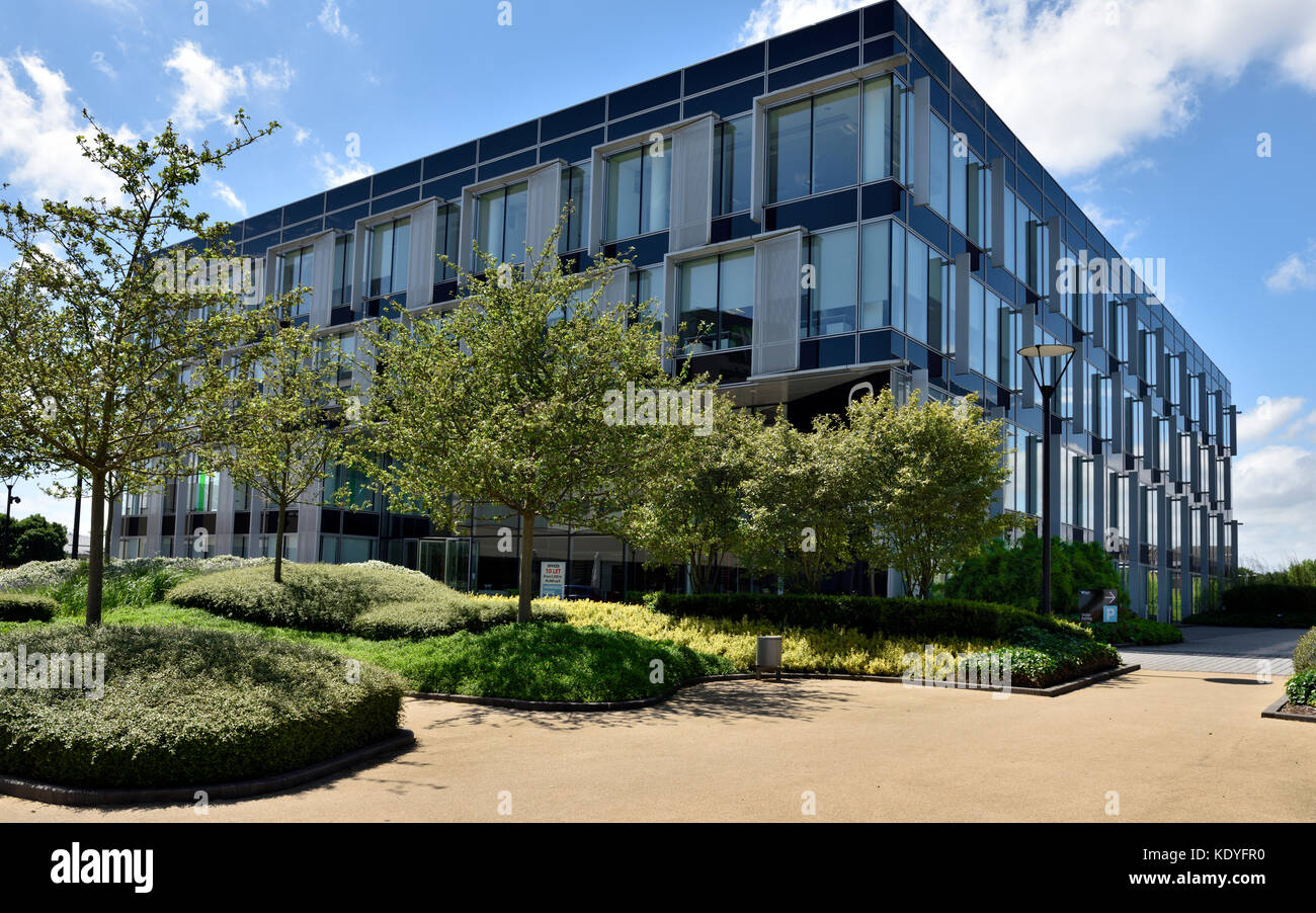 Moderne englische Bürogebäude mit benachbarten Pflanzen und gepflasterte Fläche, IQ Business Park, Wokingham, Berkshire, Großbritannien Stockfoto