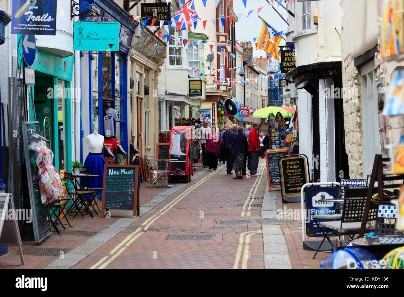 Bunte Bunting und Shop zeigt ziehen Besucher an St Alban Street, Weymouth, Dorset, Großbritannien Stockfoto