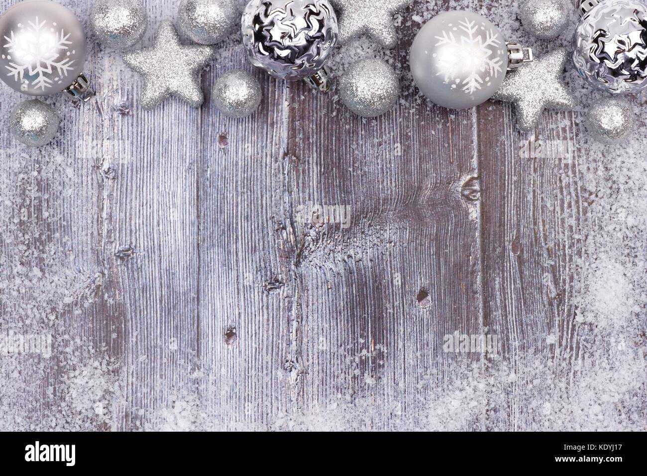 Silber Weihnachtsverzierung oberer Rand mit Schnee Rahmen auf eine rustikale Holz Hintergrund Stockfoto