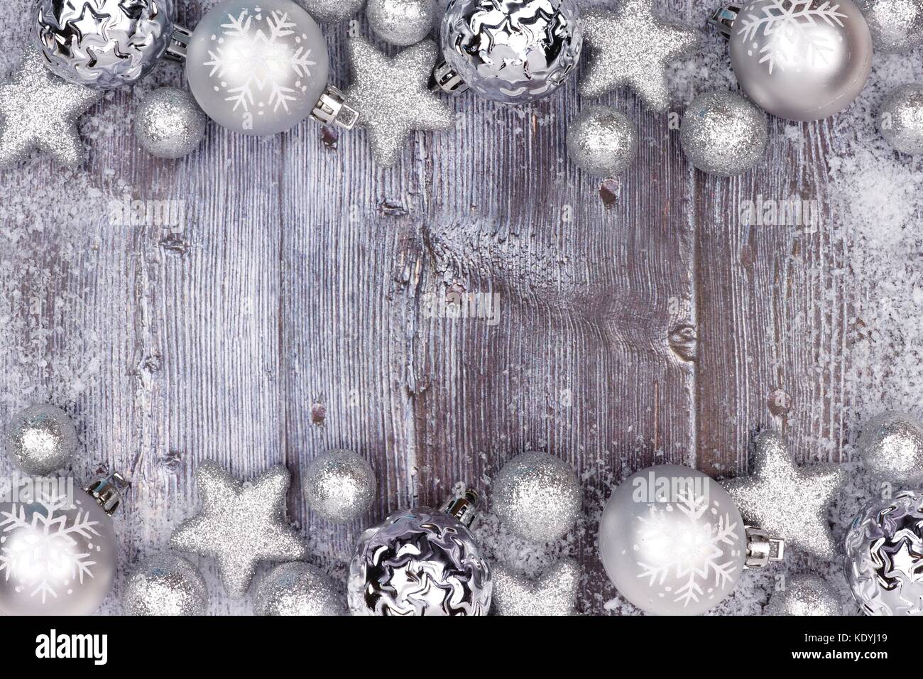 Silber Weihnachtsverzierung doppelten Umrandung mit Schnee Rahmen auf eine rustikale Holz Hintergrund Stockfoto