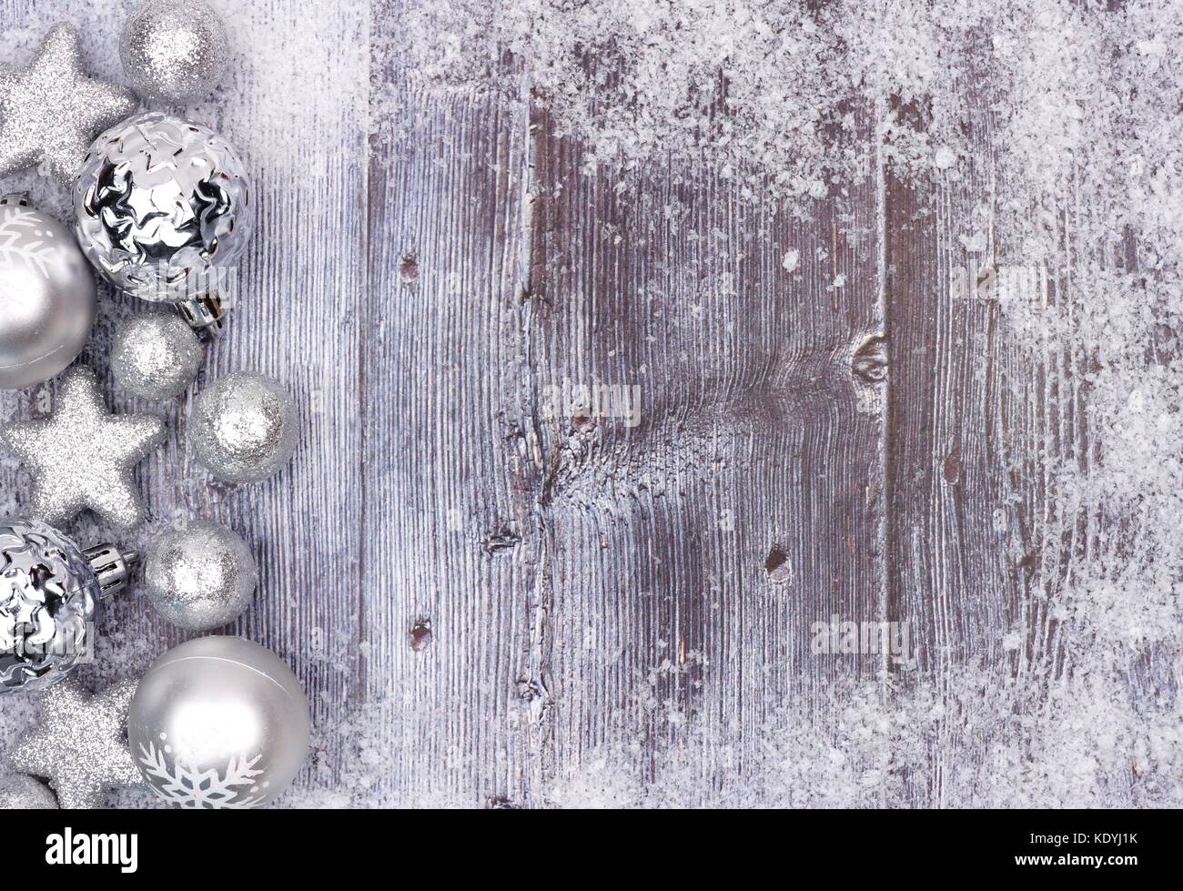 Silber Weihnachtsverzierung Seite Grenze mit Schnee Rahmen auf eine rustikale Holz Hintergrund Stockfoto
