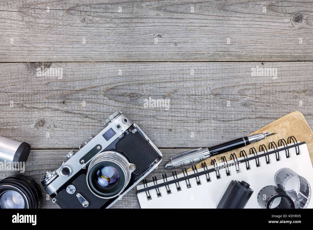 Retro Kamera, Objektive, negative Film und leer Notebook auf grau Holztisch flache Ansicht Stockfoto