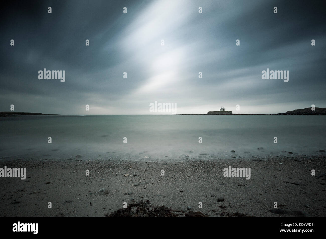 Von st cwyfan Kirche isoliert auf das horison der Irischen See als Sturm ophelia Landfall auf Anglesey, North Wales, UK macht Stockfoto