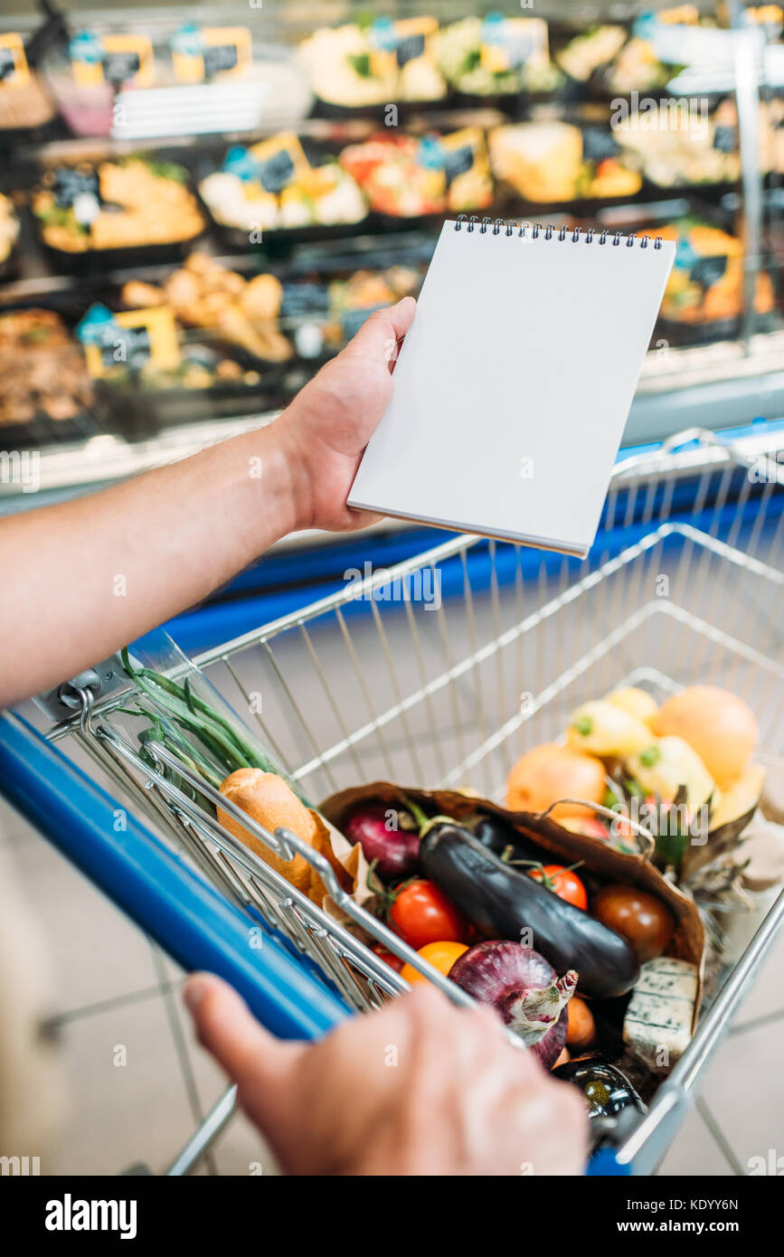 Mann mit leeren Notebook im Supermarkt Stockfoto