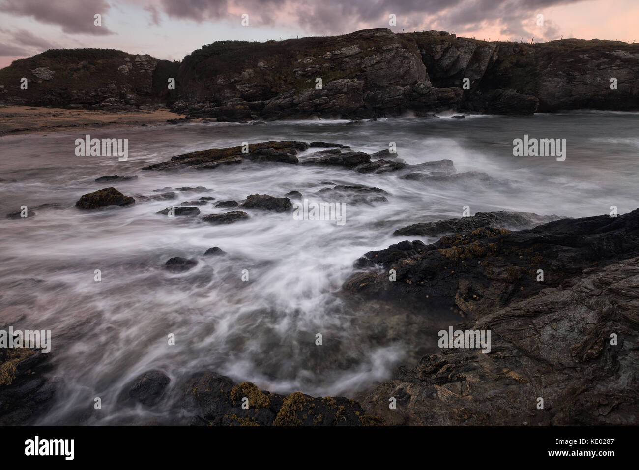 Lange exposre Treaddur bay Bild von Küste und Meer bei Sonnenuntergang, Anglesey, Wales, Großbritannien Stockfoto