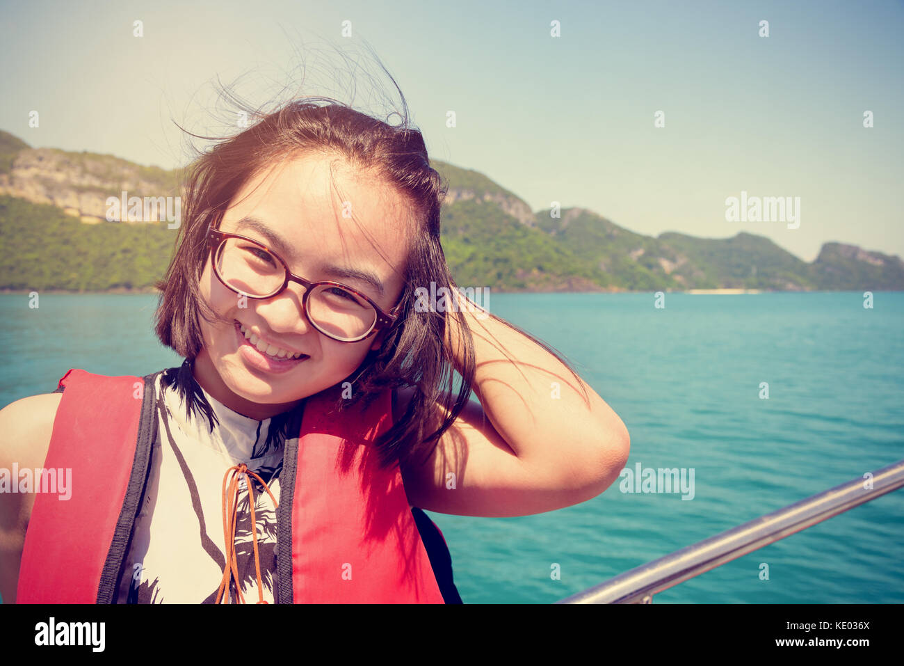 Vintage Style junge Frau mit Brille glücklich lächelnd auf dem Boot während der Fahrt die natürliche auf das Meer und die Insel im Sommer an Mu Ko Ang Thong na Stockfoto