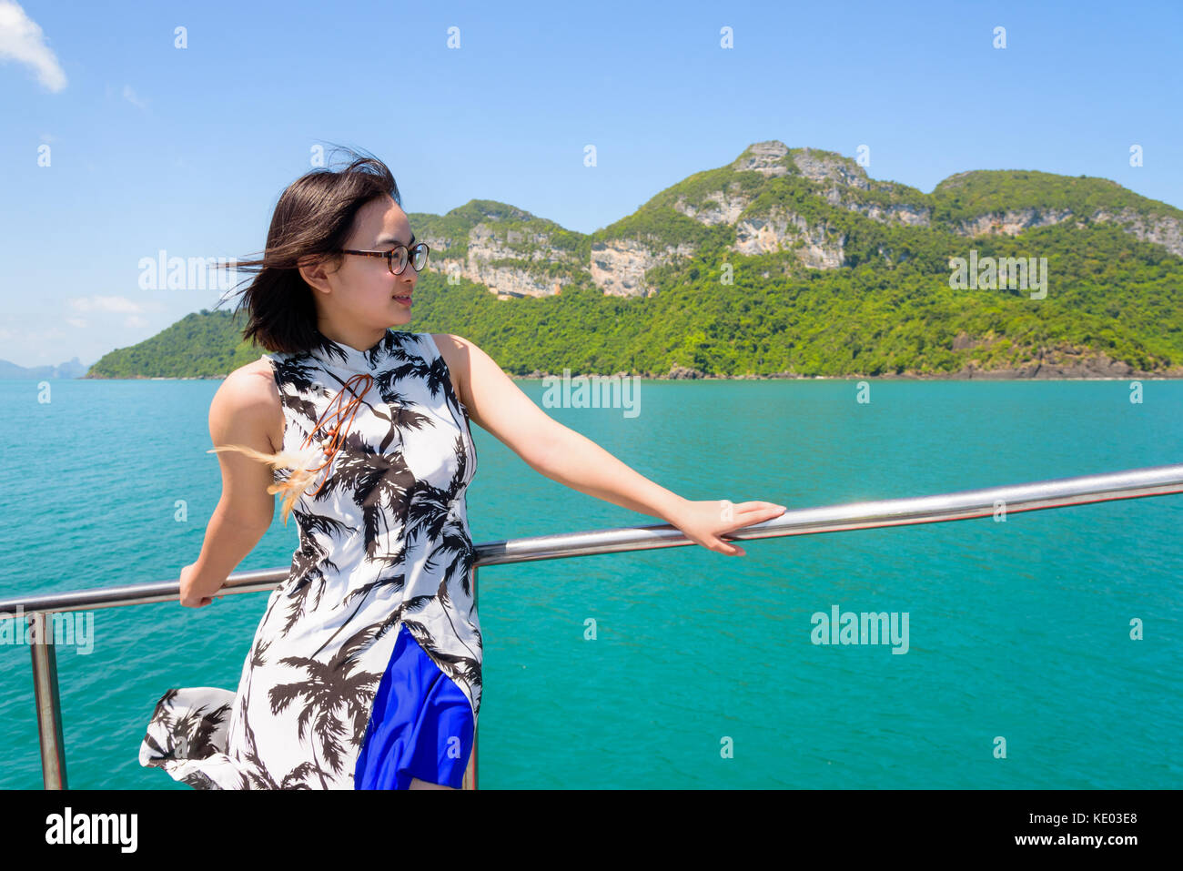 Asiatische junge Frau mit Brille glücklich lächelnd auf dem Boot, während die schöne Natur der blauen Himmel und Meer Kreuzfahrt im Sommer an Mu Ko Ang Thon Stockfoto