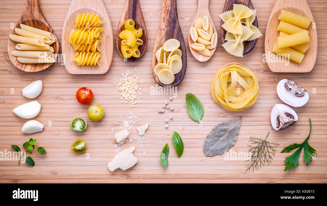 Italienisches Essen Konzept. verschiedene Nudelsorten in Holzlöffel mit ... Italienisches Essen Konzept. verschiedene Nudelsorten in Holzlöffel mit ...