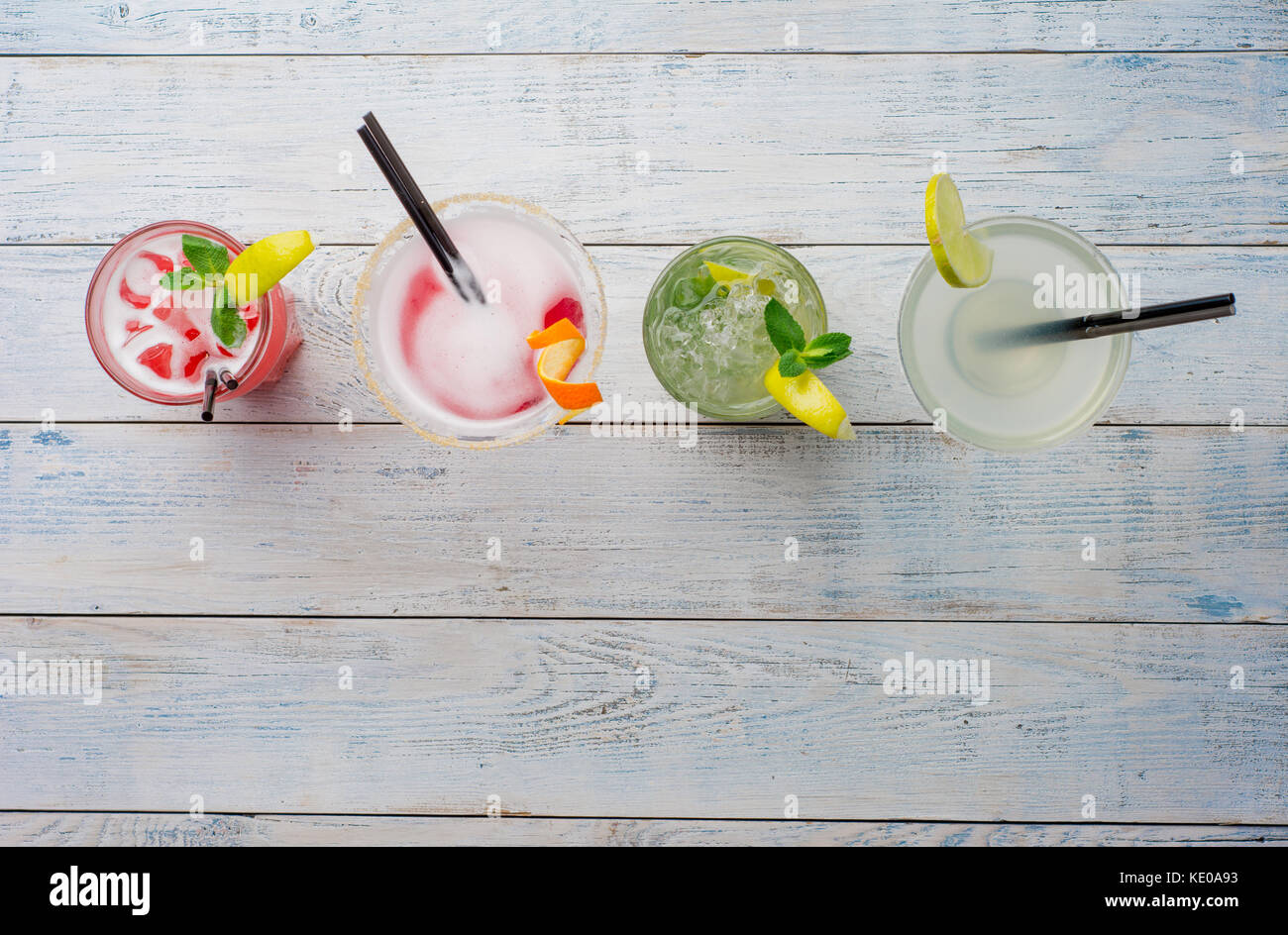 Farbenfrohe Cocktails. Mojito, rote Cocktail mit Eis und Kalk, Margarita, Cosmopolitan auf hölzernen Tisch. Stockfoto