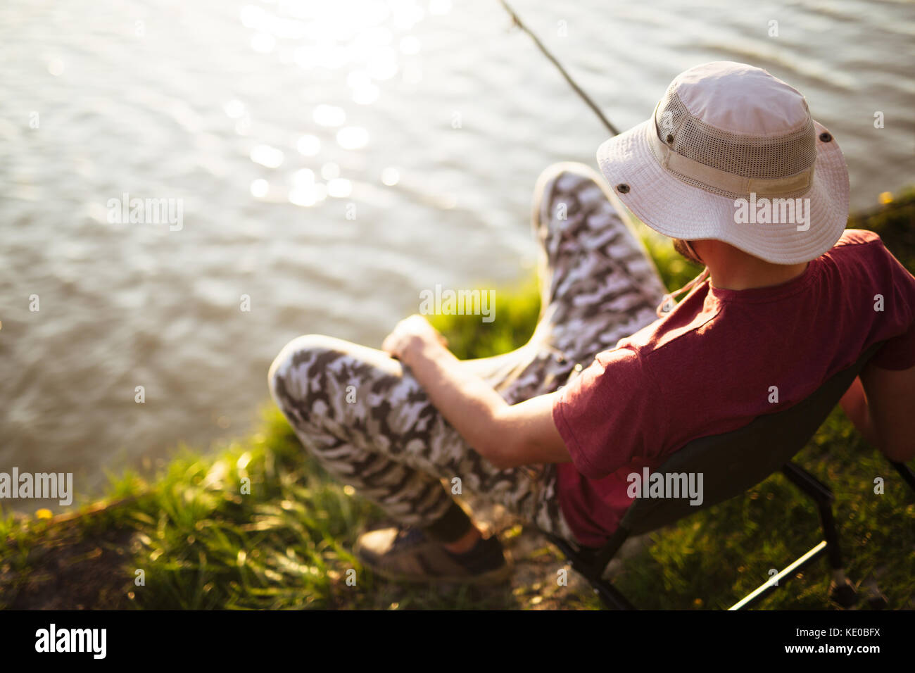 Junger Mann Angeln am Teich und Hobby Stockfoto