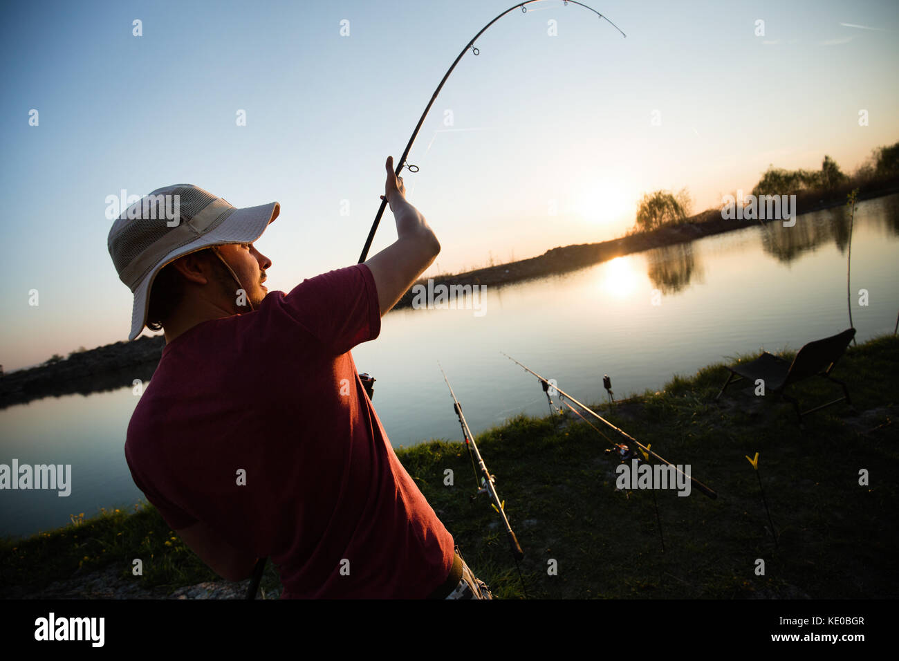 Junger Mann Angeln am Teich und Hobby Stockfoto