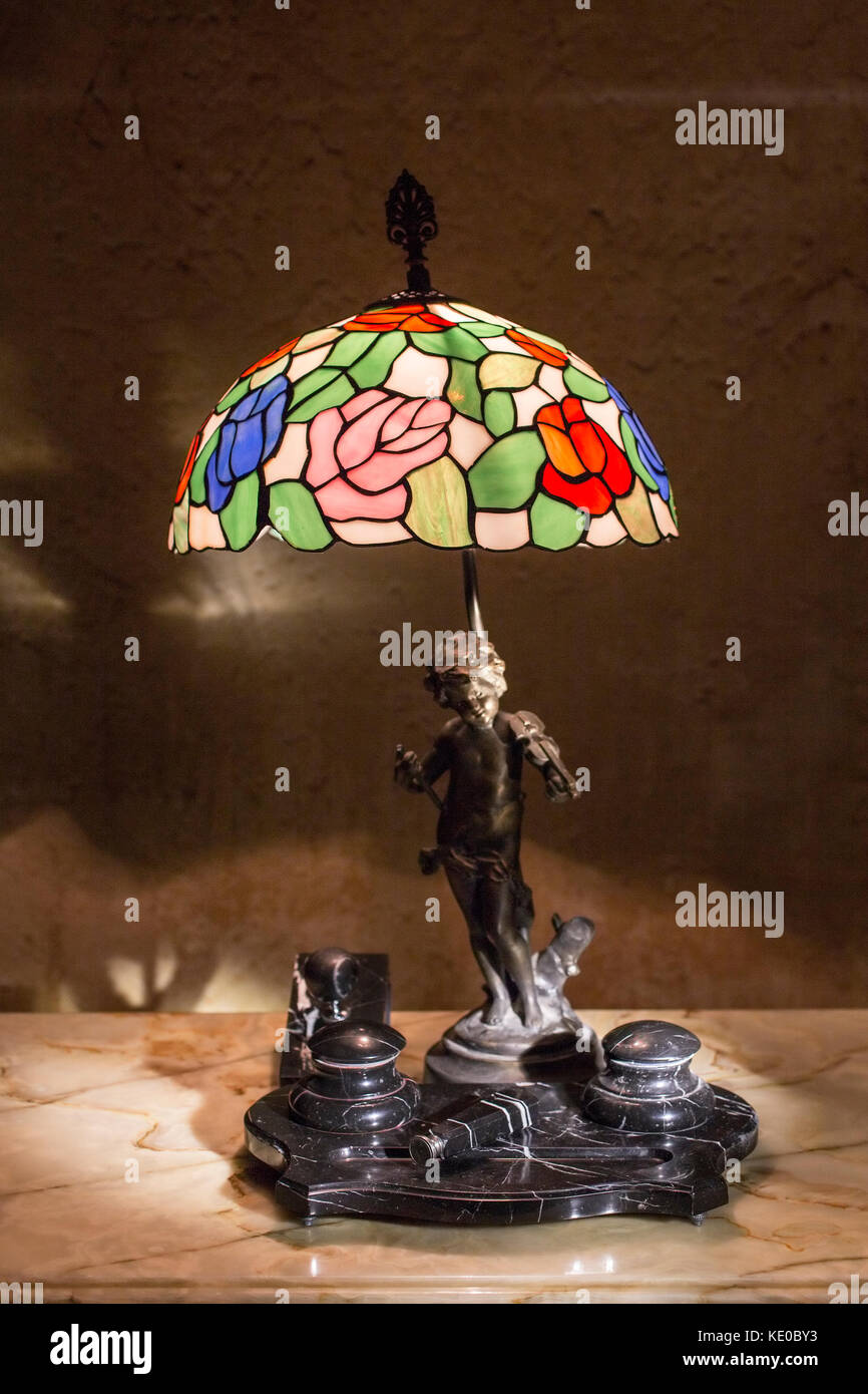Tiffany Stil blue vintage Tischleuchte mit statuette von Cupid figurel mit Geige als Pole und Marmor Tintenfass. Stockfoto