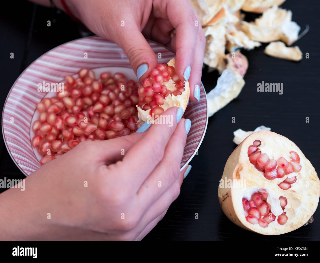 Frau peeling Granatapfel Samen in Schüssel, Ansicht von oben Stockfoto