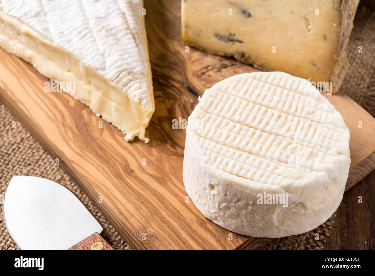 Holzbrett mit Käse und Messer Stockfoto