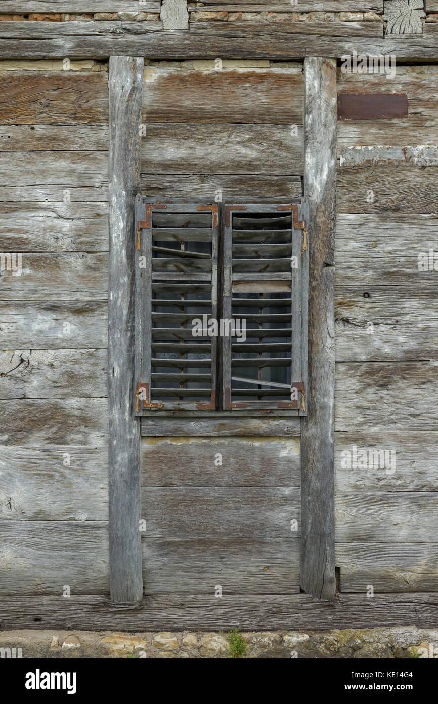 Alte Holz- Fenster mit Holzjalousien auf einem verlassenen Holzhaus Stockfoto