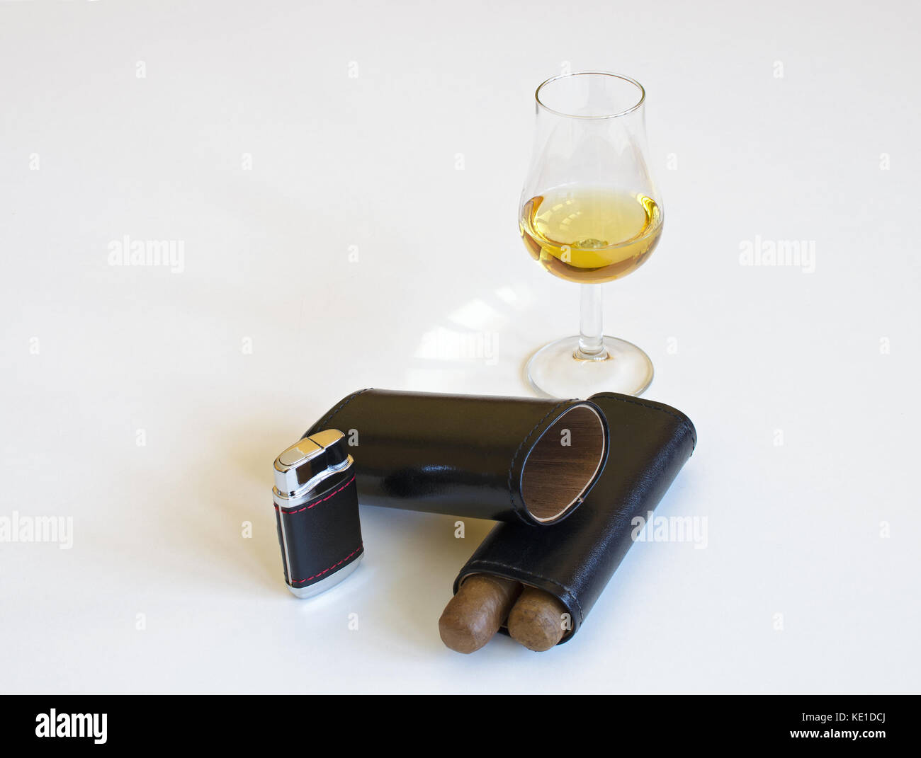 Glas Whiskey und zwei Zigarren, Leder, Schwarz, Zigarettenanzünder, auf weißem Hintergrund Stockfoto