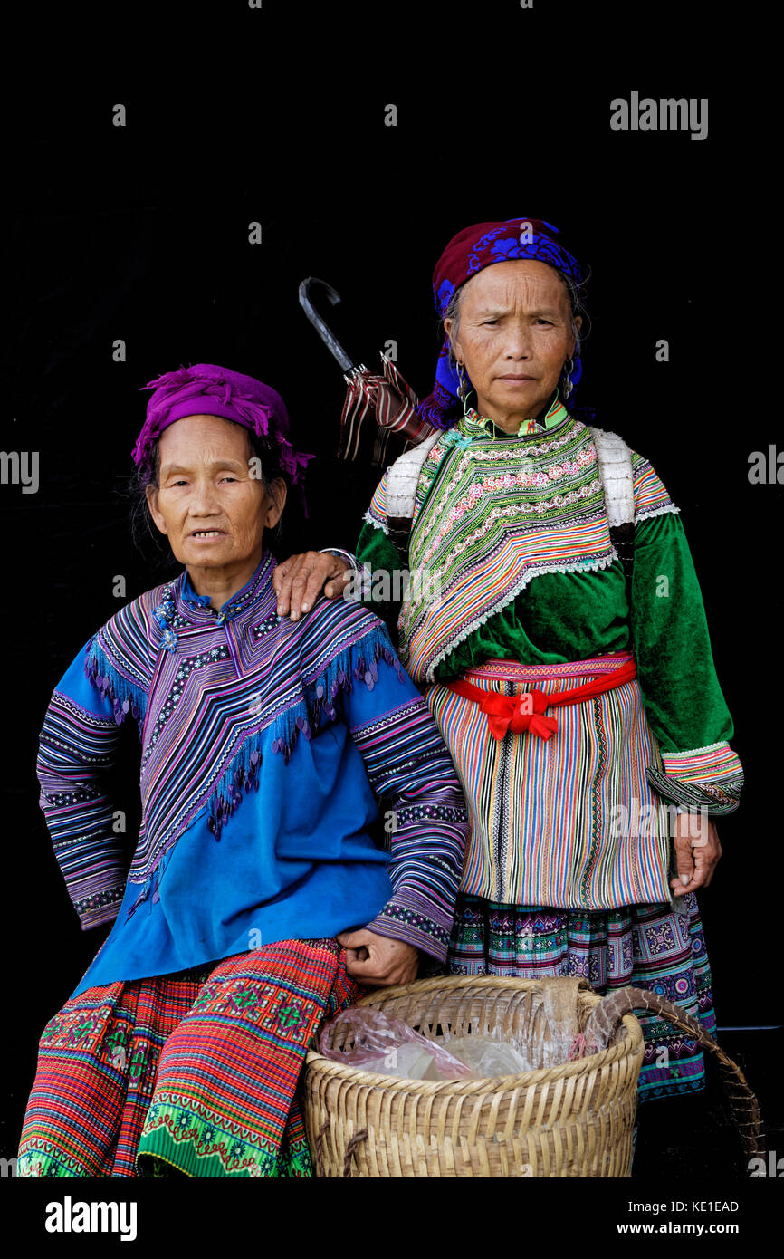 Sünde Cheng, Vietnam, 26. Oktober 2016: Frauen vor einem schwarzen Blatt. HMong Frauen im Norden Vietnams tragen ihre beste traditionelle Kleidung beim Gehen zu Stockfoto