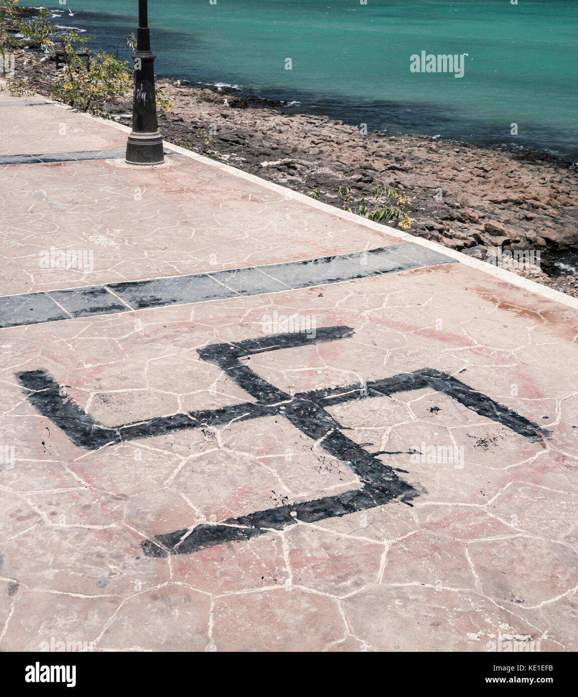 Hakenkreuz gemalt auf Pflaster an der Küste in Spanien Stockfoto