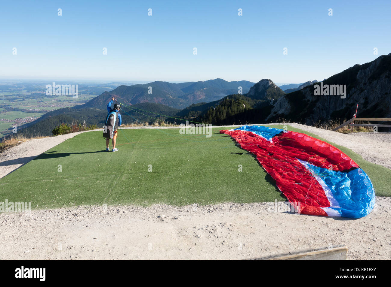 Der Mensch bereitet seinen Hang Glider vor dem Abheben vom Berg Stockfoto