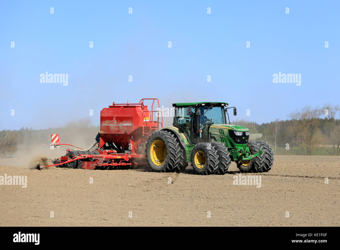 Salo, Finnland - 8. Mai 2016: John Deere 6125r Traktoren und Horsch Drillmaschine auf staubigen Feld an der Frühling mit blauem Himmel. Stockfoto