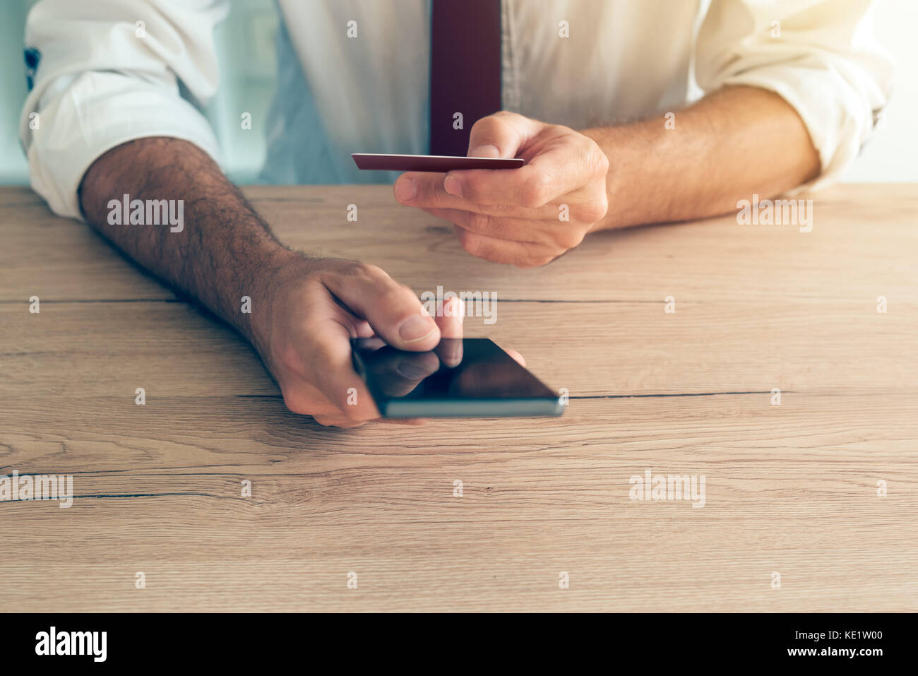 Mobile Banking Smartphone App von Geschäftsmann im Büro Schreibtisch benutzt. Nach kaukasischen Geschäft Person anschließen Kreditkarte, Internet-e online-banking Stockfoto