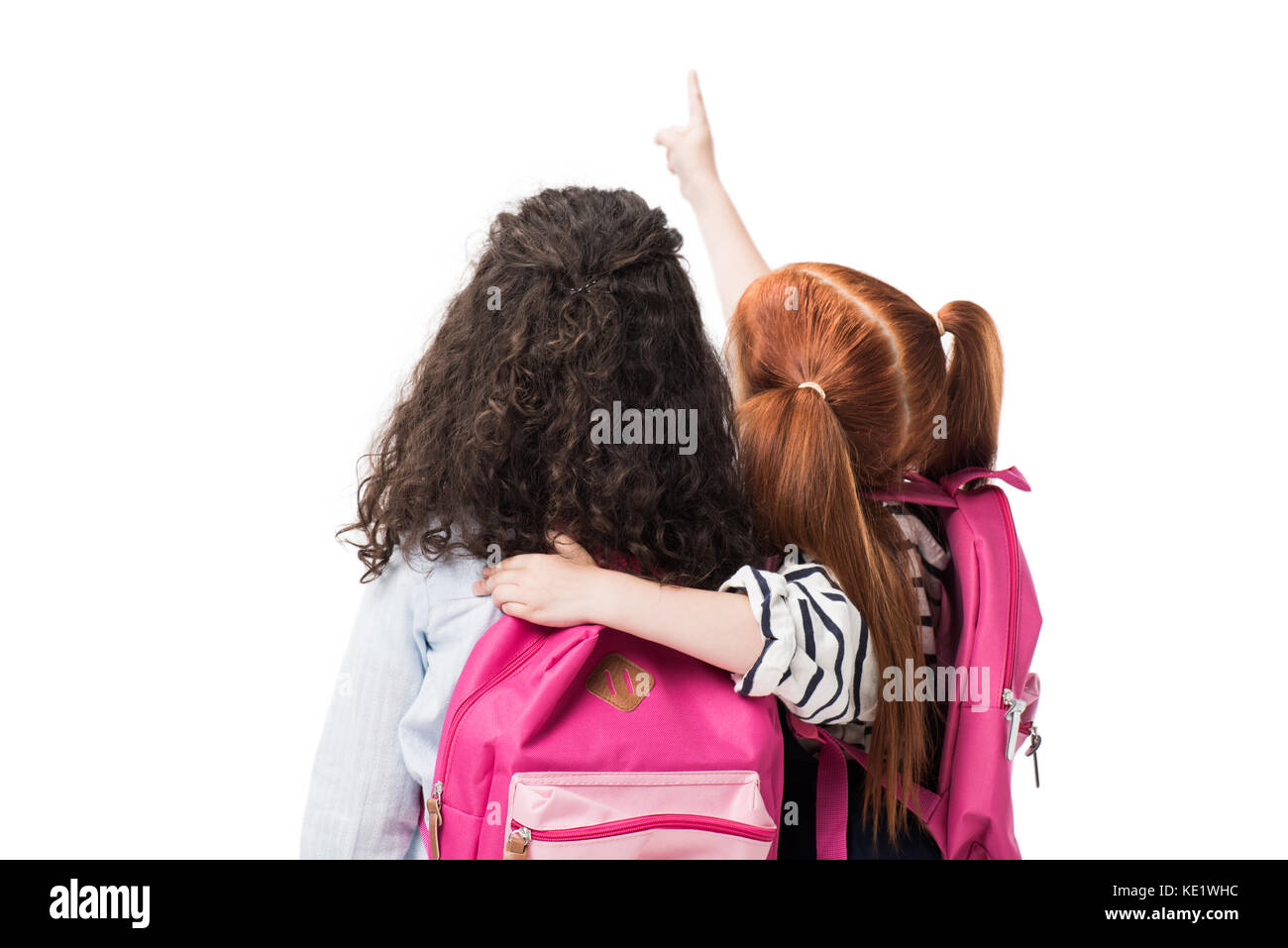 Rückansicht des niedlichen multiethnischen Schülerinnen mit Rucksäcken gemeinsam isoliert auf weißem Stockfoto