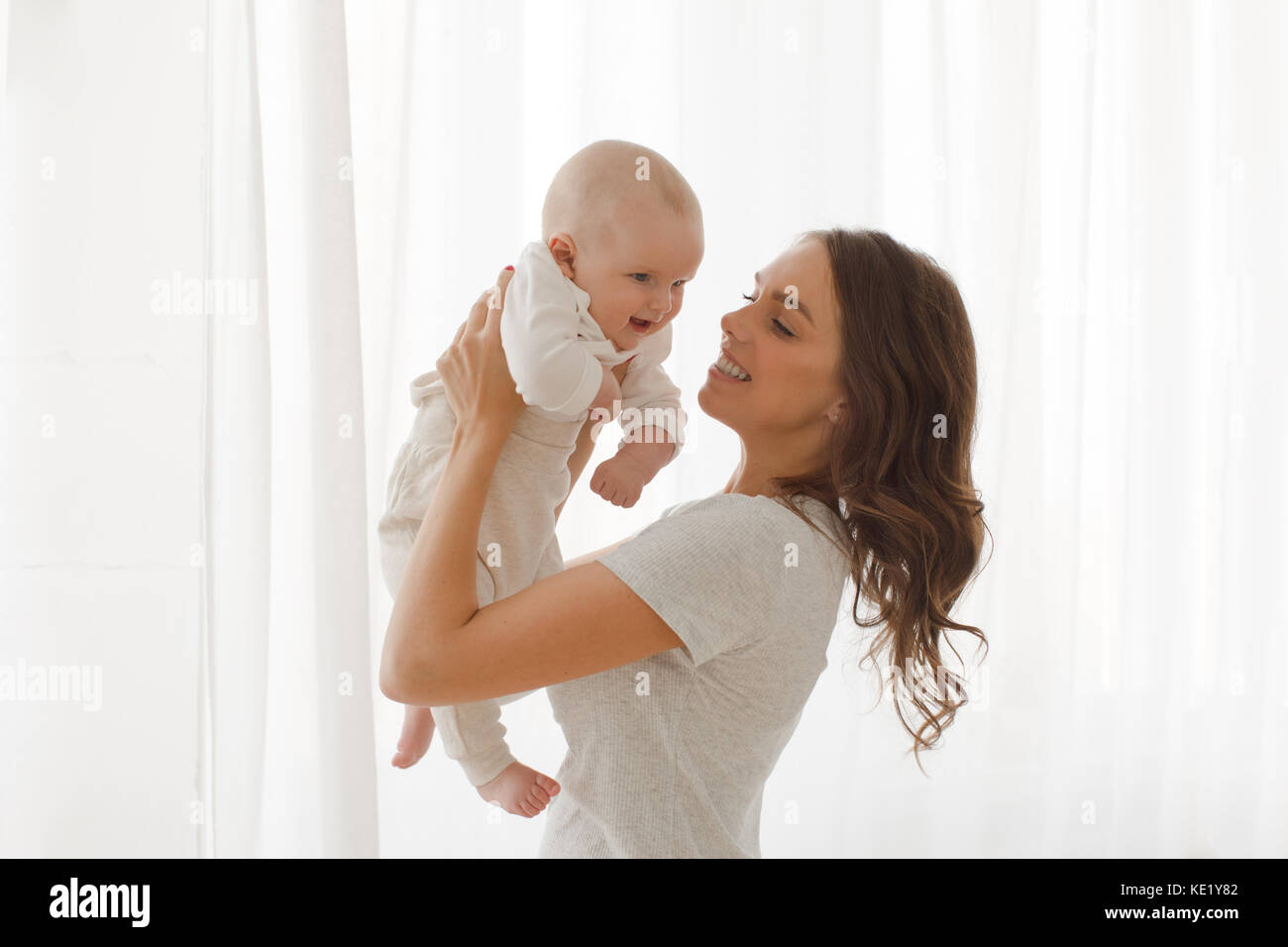 Mama hält ein Baby in den Armen windowon weißer Hintergrund Stockfoto