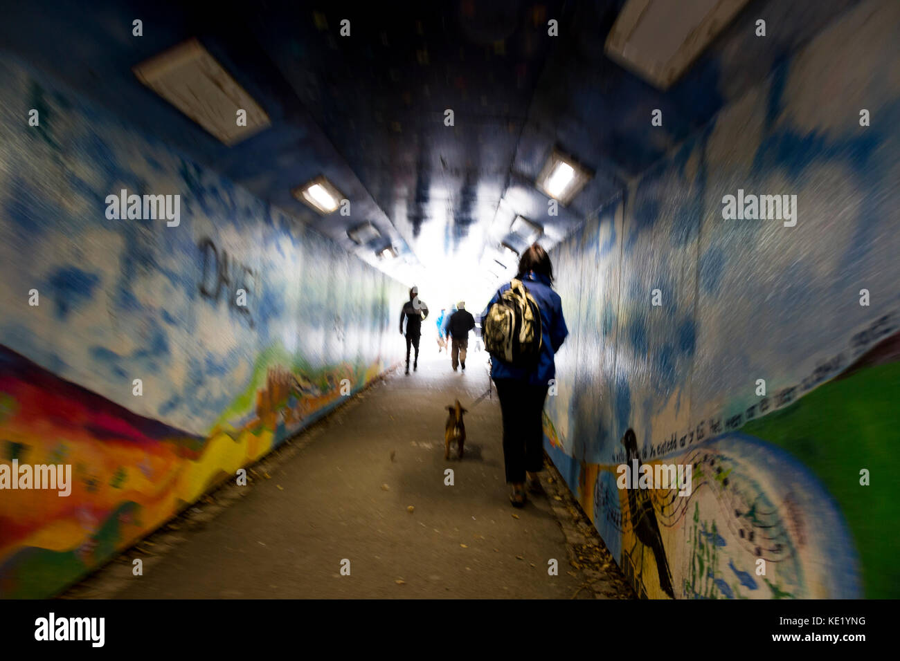 Surreale Ansicht von Fußgängern verschwommene Bewegung im Lackierten graffiti Unterführung Stockfoto
