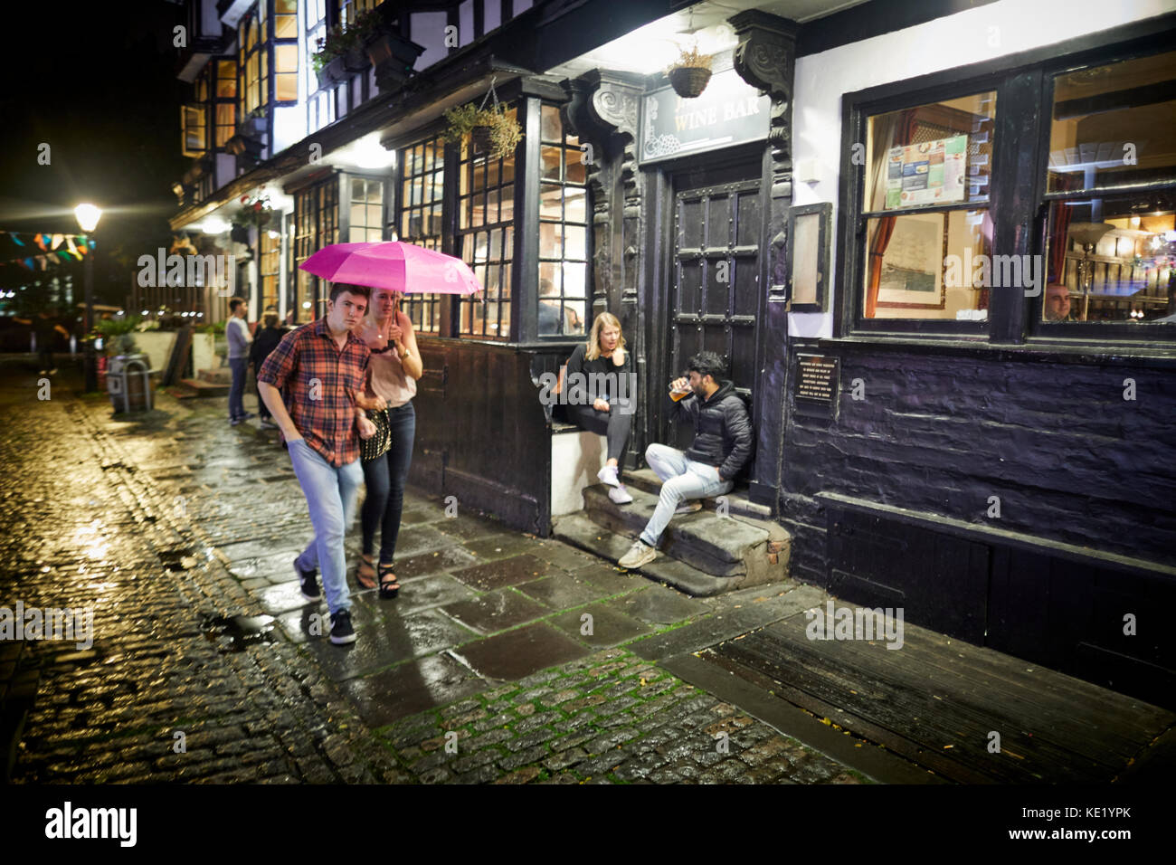 Bis spät in die Nacht Trinken in der King Street in Bristol als Paar, im Regen unter einem Sonnenschirm Stockfoto