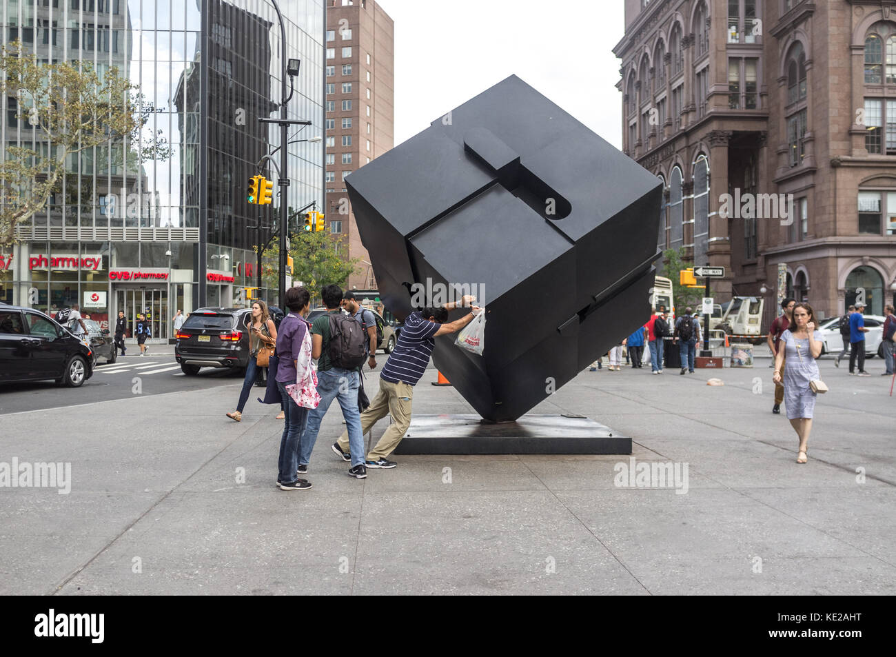 Man drückt die Alamo Astor Place cube Skulptur am Astor Place, Manhattan, New York City. Stockfoto