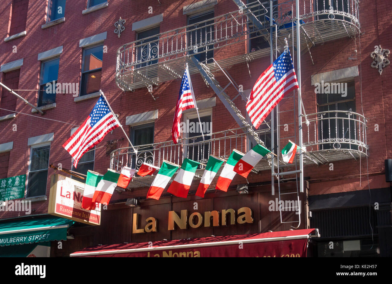Amerikanische und Italienische Flaggen fliegen Seite an Seite über dem Eingang La Nonna Restaurant auf Mulberry Street in Little Italy Stockfoto