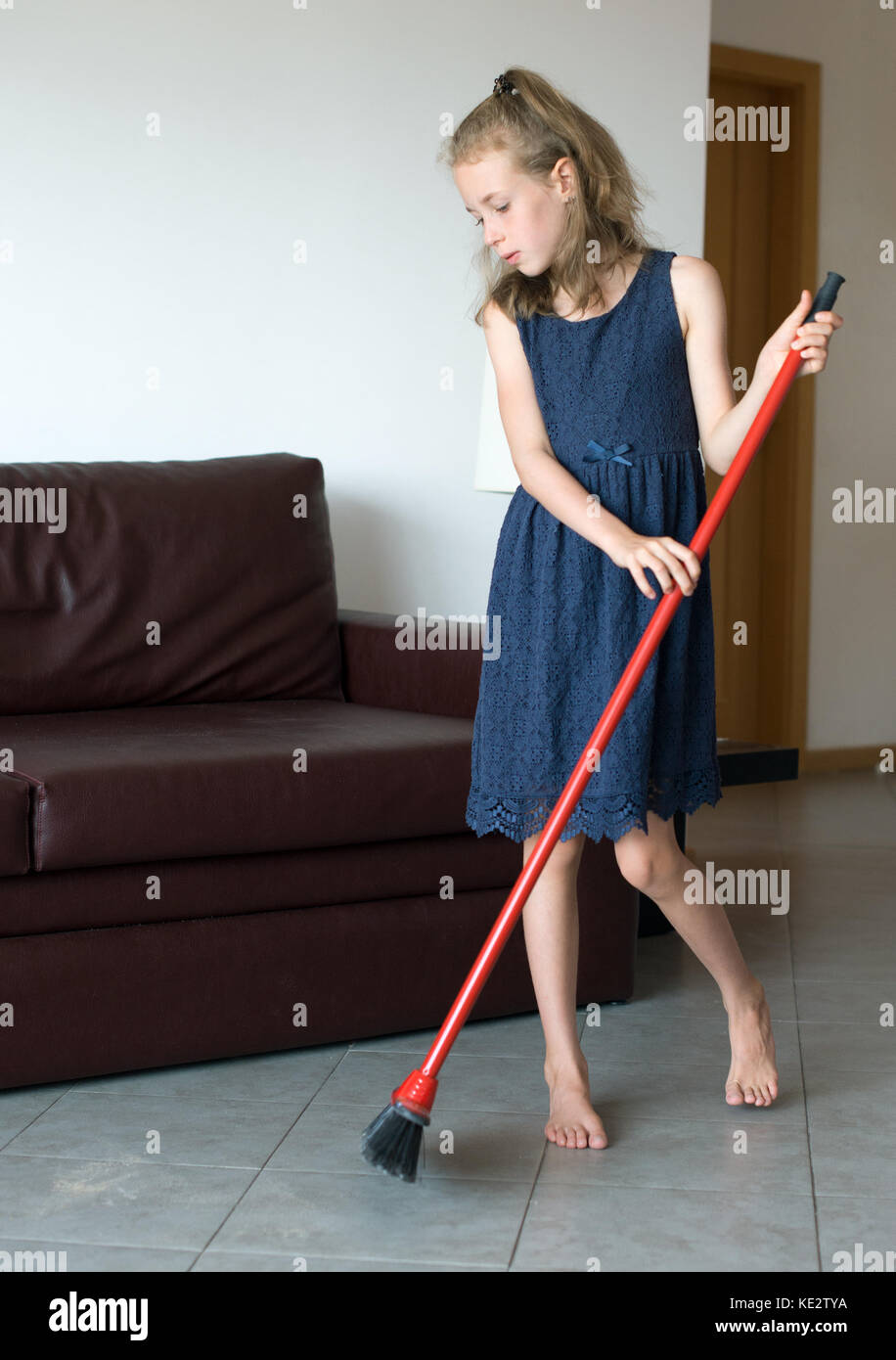 Das kleine Mädchen putzt die Wohnung. Stockfoto