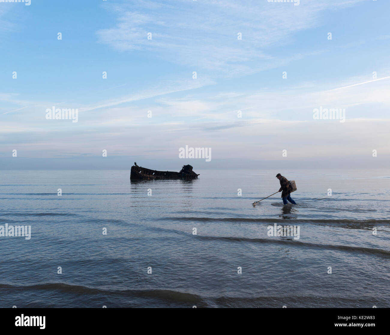 Ein Fischer Spaziergänge entlang der Küste vor einem schiffbruch an der Küste von Kent Stockfoto