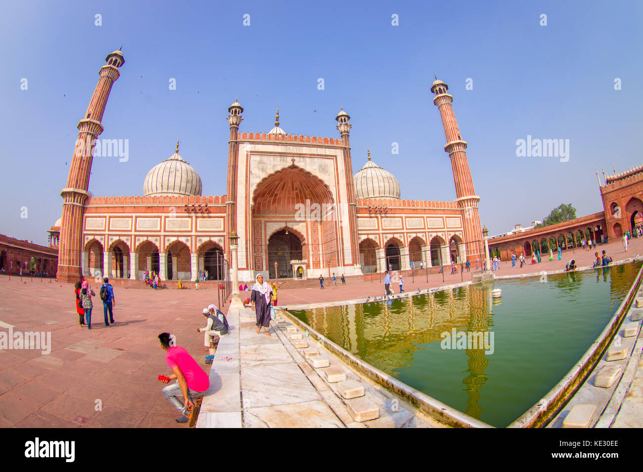Delhi, Indien - 27. September 2017: unbekannte Menschen zu Fuß in der Nähe des künstlichen Teich vor einem wunderschönen Jama Masjid Tempel, das ist die größte Moschee in Indien Delhi, Indien, Fischaugen-Effekt Stockfoto