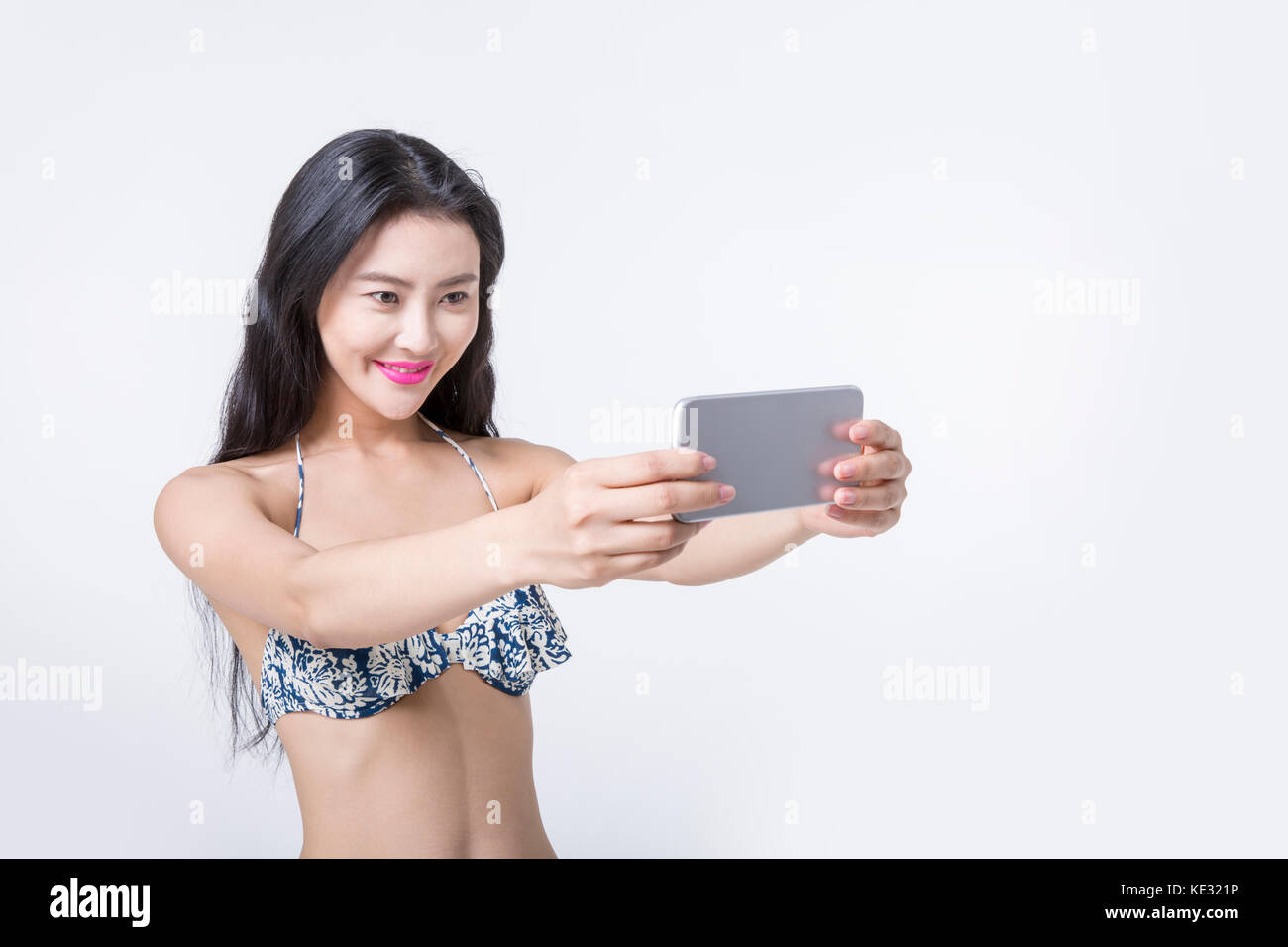 Portrait der junge lächelnde schlanke Frau im Bikini ein selfie Stockfoto