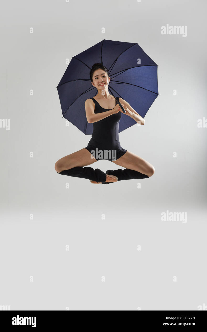 Junge lächelnde Ballerina in schwarz Body posing elegant Holding einen  Regenschirm Stockfotografie - Alamy
