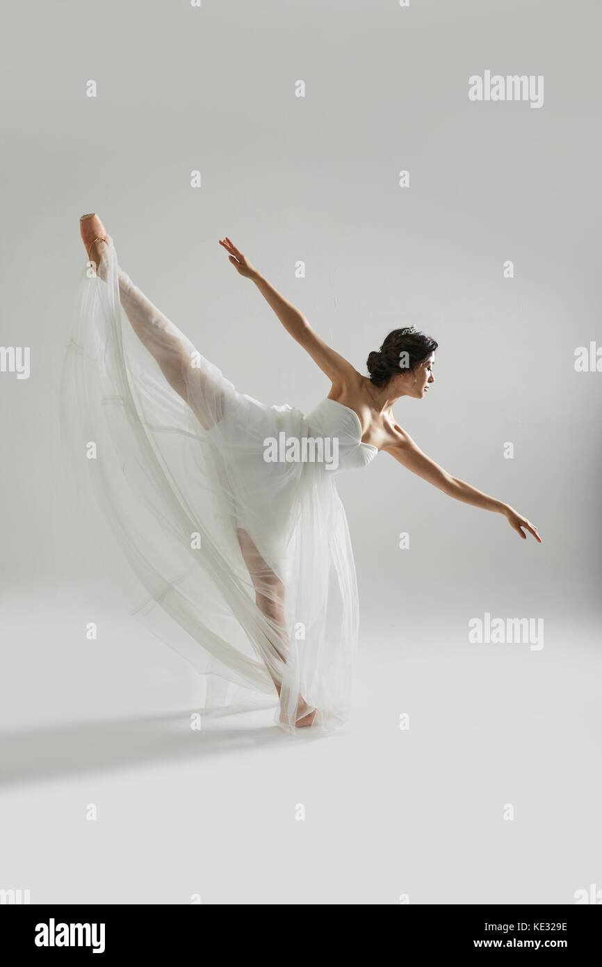 Seitenansicht des jungen Ballerina in weißem Kleid elegant Posing Stockfoto