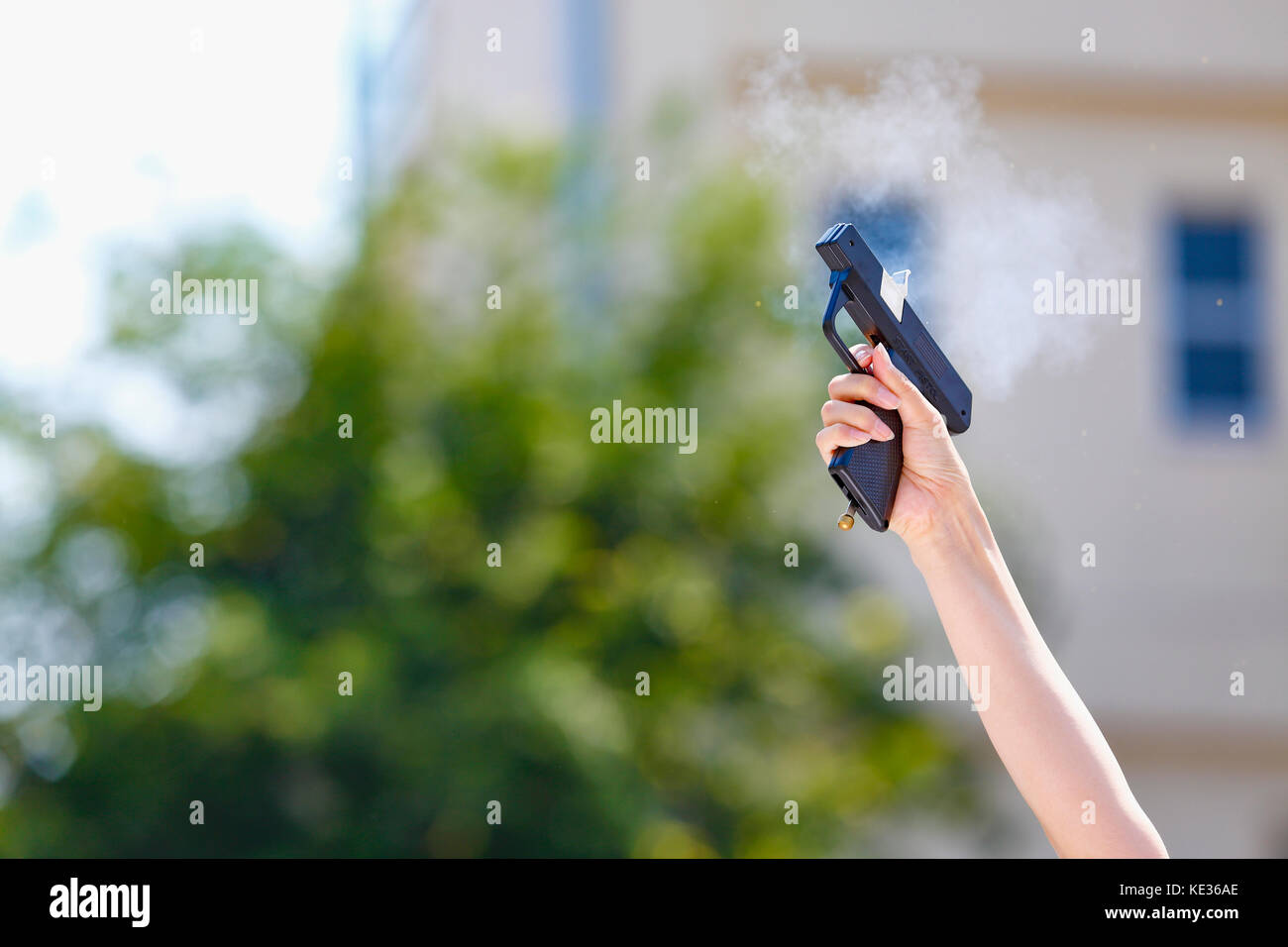 Hand hält Starterpistole im Schulgarten Stockfoto